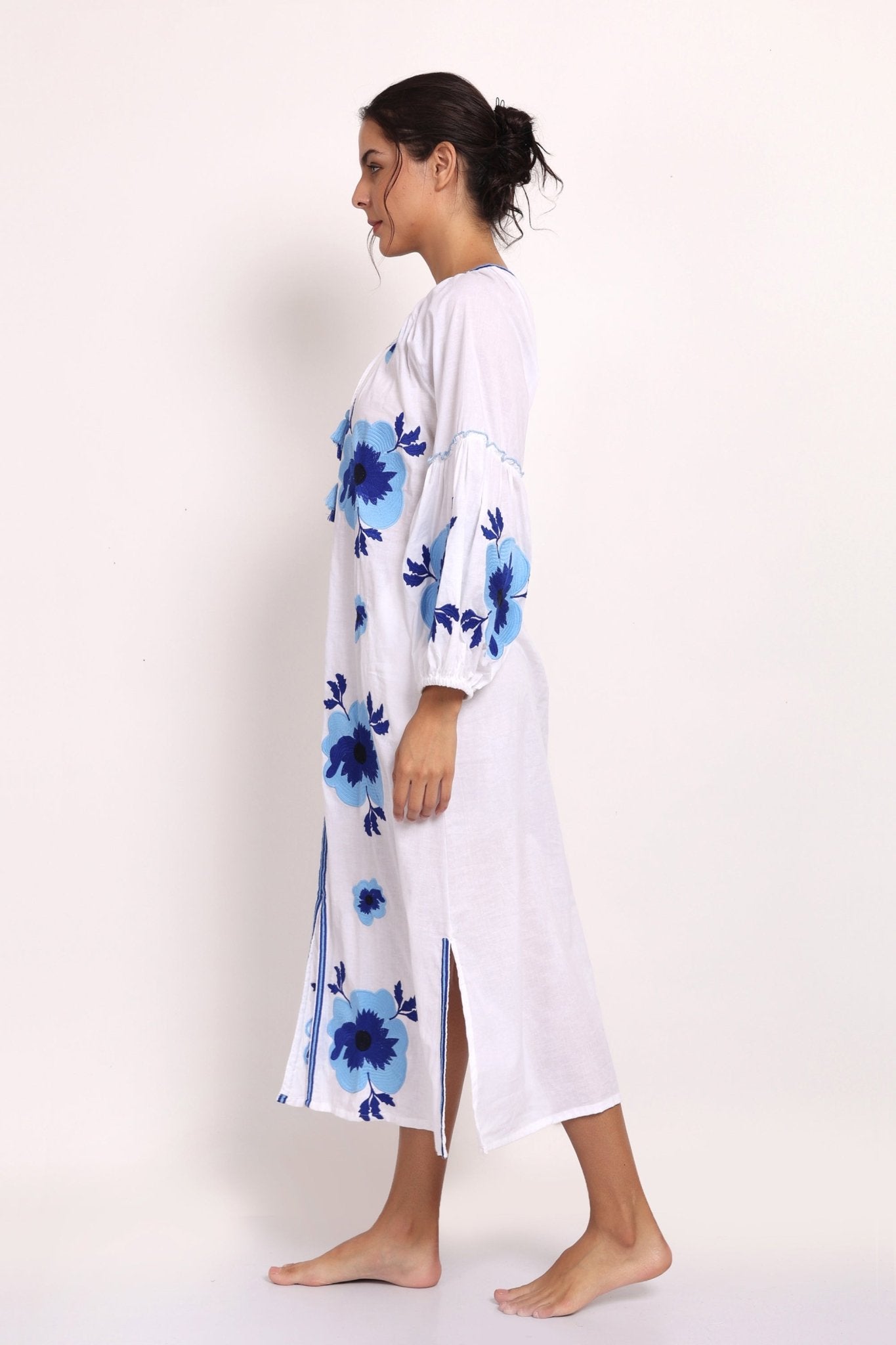 Side view of embroidered white cotton sundress showing flowy drape and hemline.