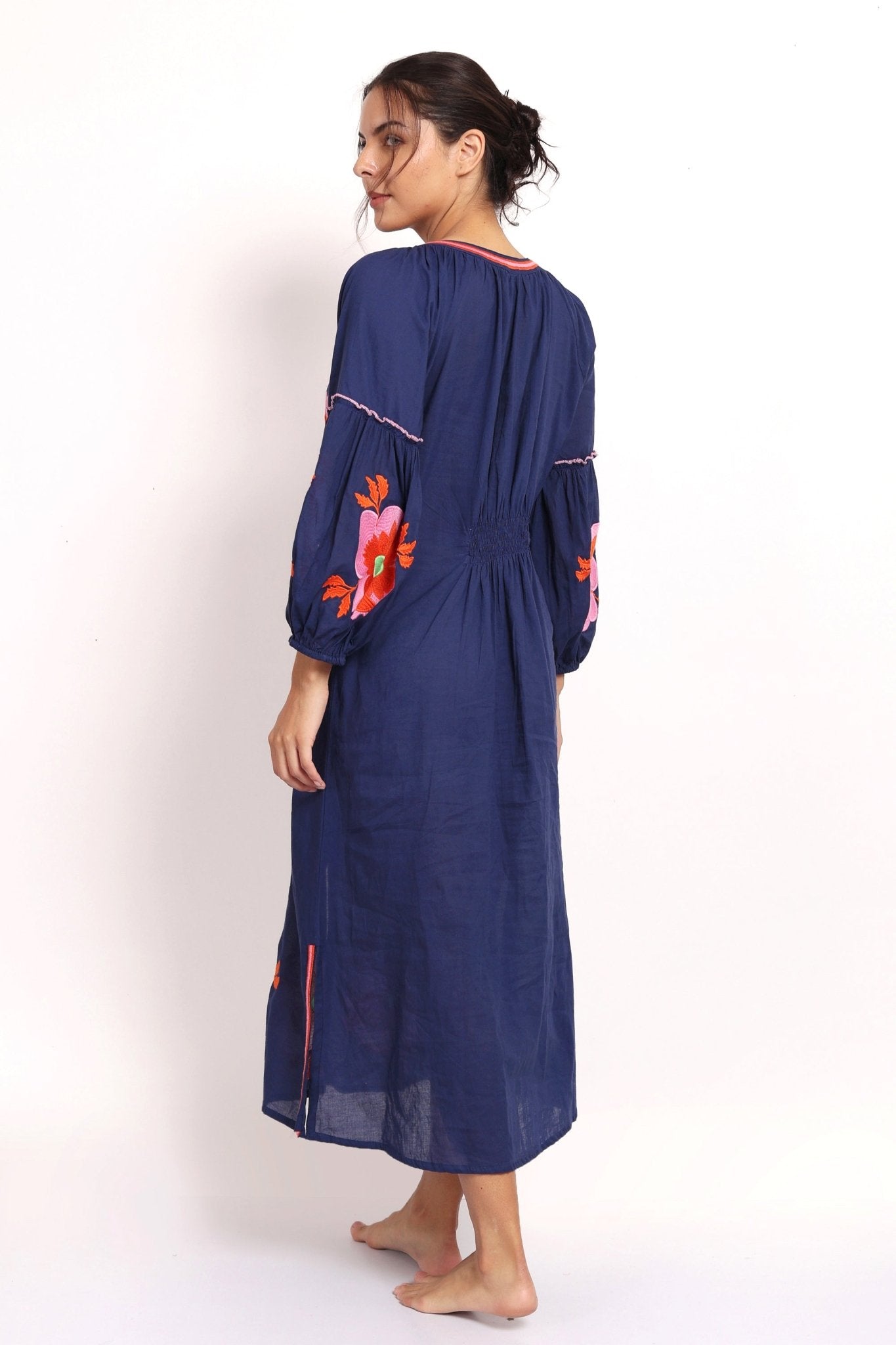 Back view of navy embroidered summer dress with elasticized panel.