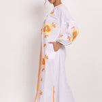 Side view of cotton sundress showing floral embroidery and split hemline.