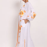 Side view of cotton sundress showing floral embroidery and split hemline.