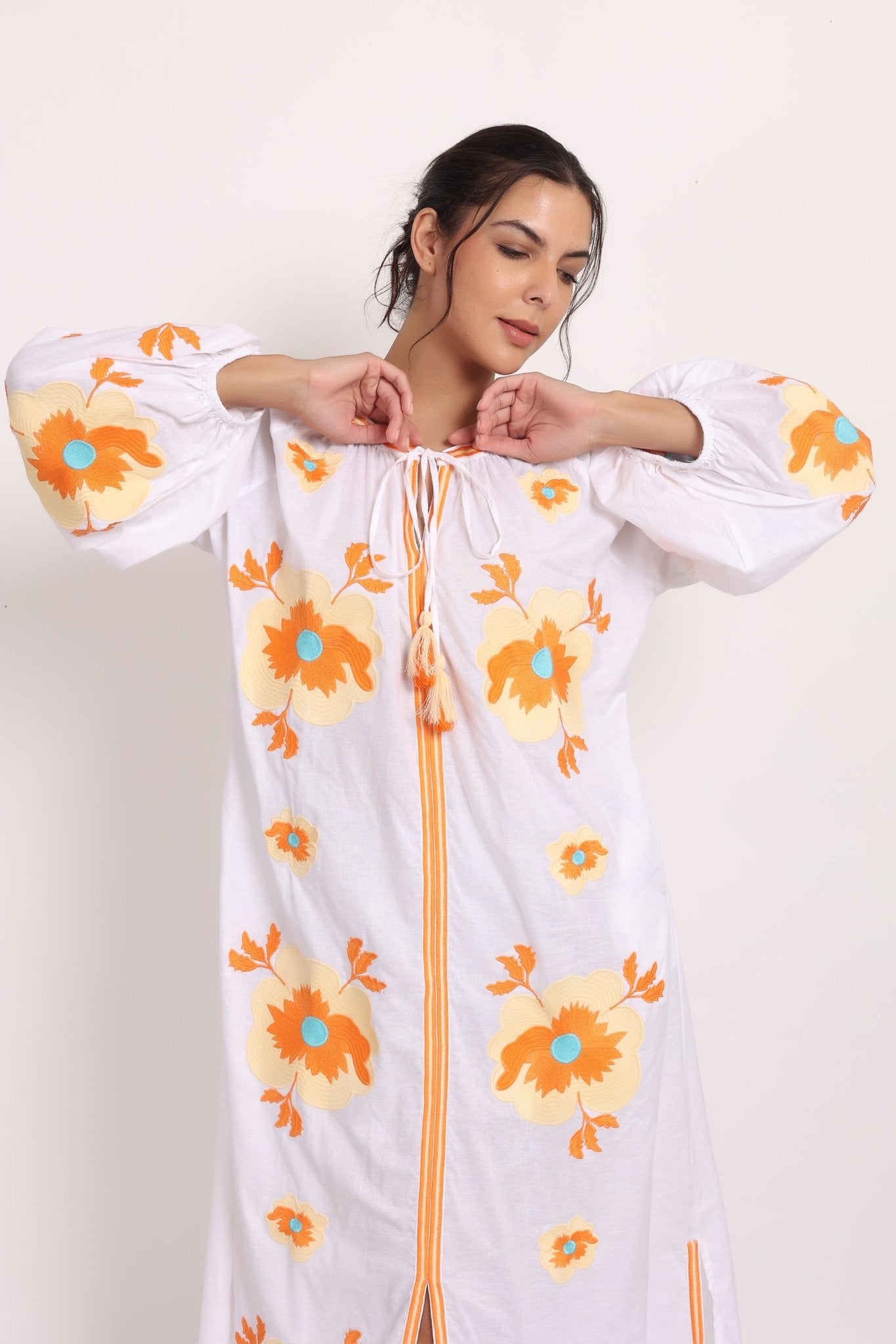 Model with arms raised in Romani sun dress, highlighting comfort and style.
