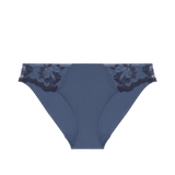 Flat lay of the Intrigue Bikini Brief Cinder Blue, highlighting embroidered tulle and scalloped velvet edges, available at The Foundation.