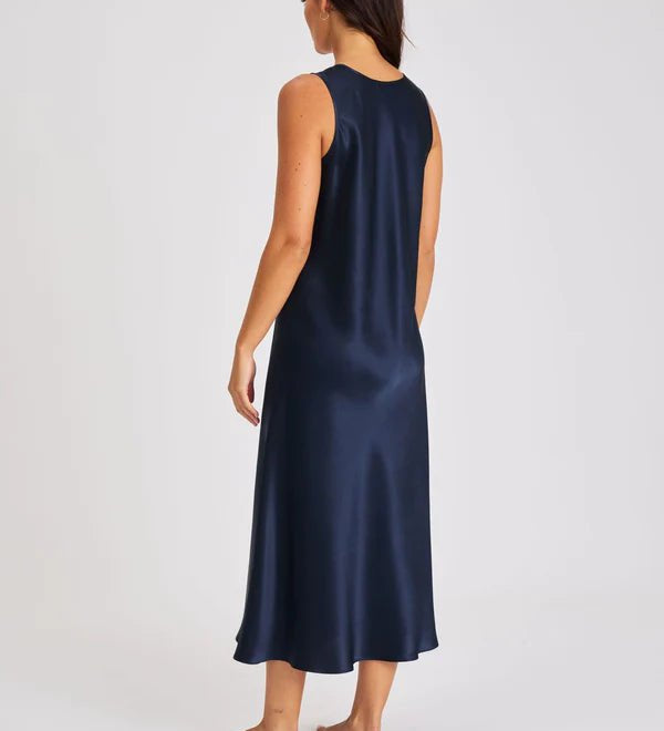 Back view of Model walking in navy long silk chemise showcasing bias-cut drape and elegant movement.
