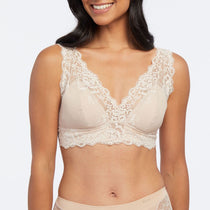 Model wearing Janira Greta Bralette in Dune, showing scalloped lace detail and fuller coverage.
