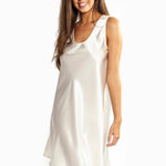 Woman wearing Mono Silk Short Nightie in ivory, featuring wide straps, low curved bust, and elegant drape cut above the knee.
