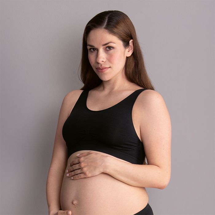 Pregnant model in Anita Seamless Maternity Sleep Bra Weiss Black, showing soft wirefree fit and gentle support, maternity comfort by The Foundation.