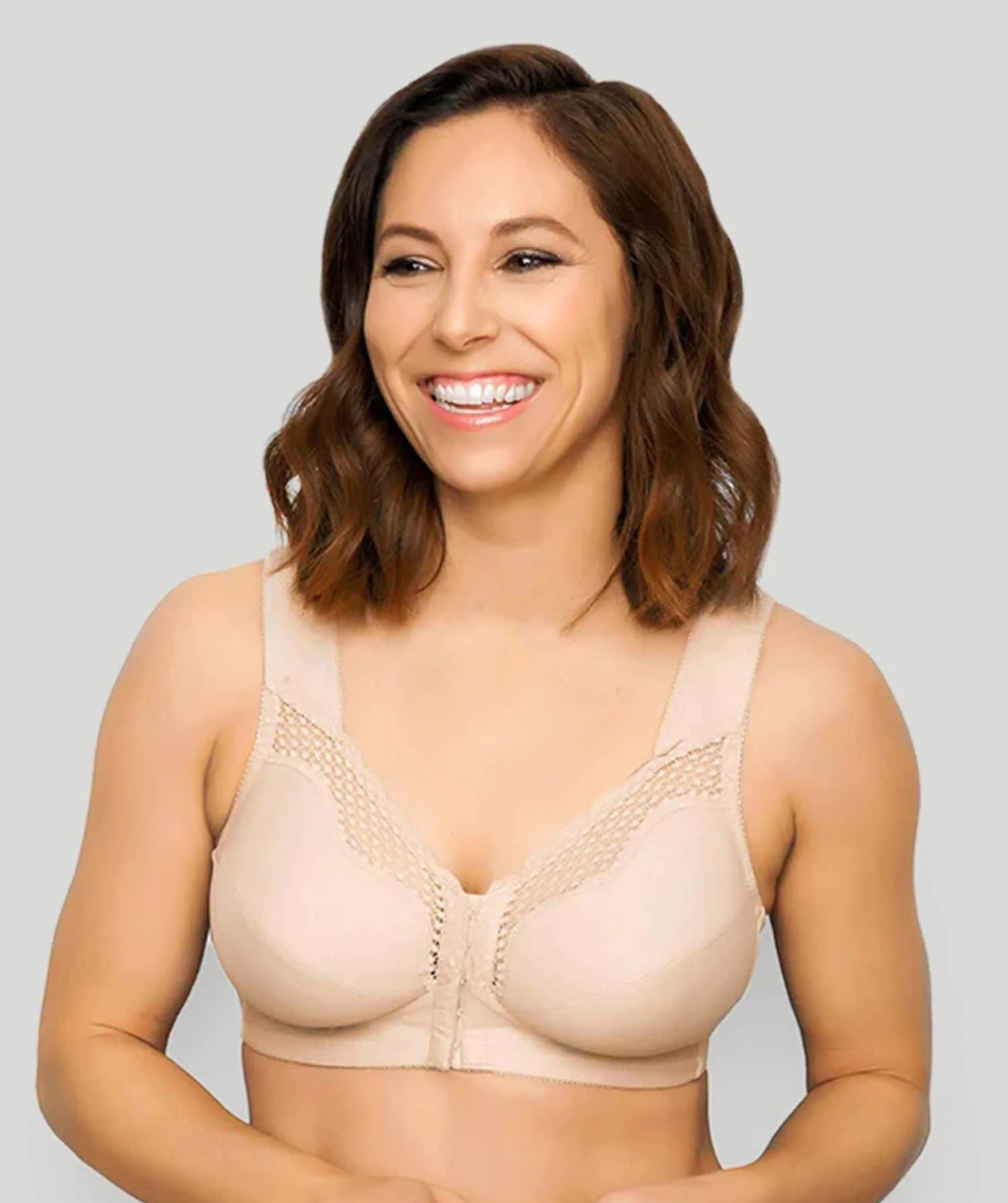 Woman wearing a beige bra against a plain background