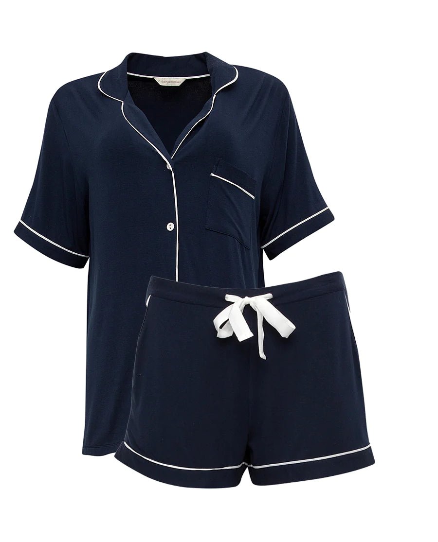 Flat lay of the Revere Jersey Shorty Set in navy, highlighting design details including contrast piping and modal-covered buttons.