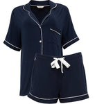 Flat lay of the Revere Jersey Shorty Set in navy, highlighting design details including contrast piping and modal-covered buttons.