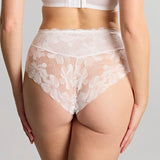 Woman wearing a white lace lingerie set on a plain background