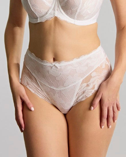 Woman wearing a white bra and panties set against a plain background