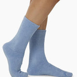 The Foundation’s brushed bamboo bed socks in blue, shown worn for a snug fit—ideal for warmth, softness, and indoor comfort.
