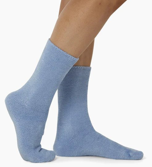 The Foundation’s brushed bamboo bed socks in blue, shown worn for a snug fit—ideal for warmth, softness, and indoor comfort.