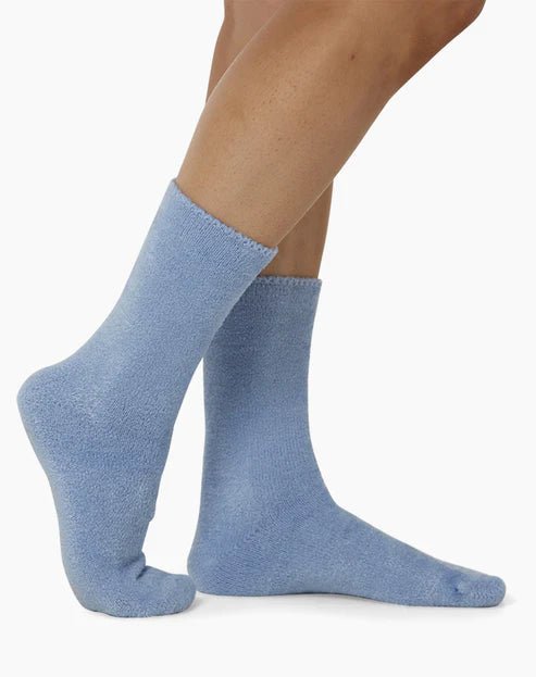 The Foundation’s brushed bamboo bed socks in blue, shown worn for a snug fit—ideal for warmth, softness, and indoor comfort.