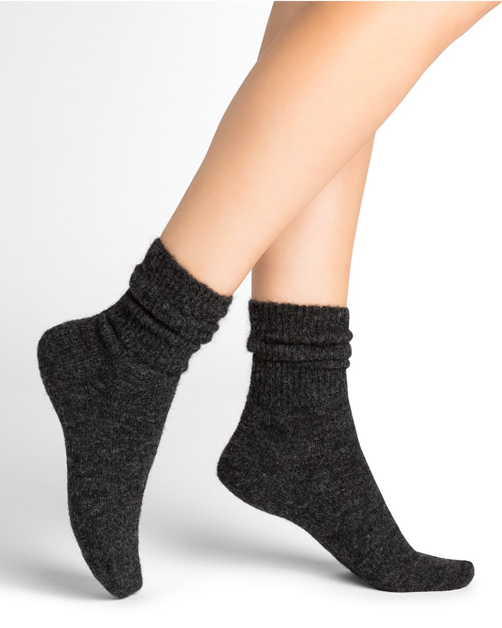 Model wearing Bleuforet Alpaca Wool Socks in Anthracite, mid-length women’s socks with gentle ribbing and reinforced heels and toes, available at The Foundation.
