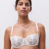Model wearing Chantelle Fleurs Satin Half Cup Bra in ivory, delicate lace and satin overlay, low neck bridal bra.