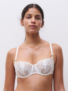 Model wearing Chantelle Fleurs Satin Half Cup Bra in ivory, delicate lace and satin overlay, low neck bridal bra.