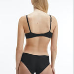 Back view of model in Calvin Klein Perfectly Fit T-Shirt Bra Black, showing adjustable straps and logo detail on the band.