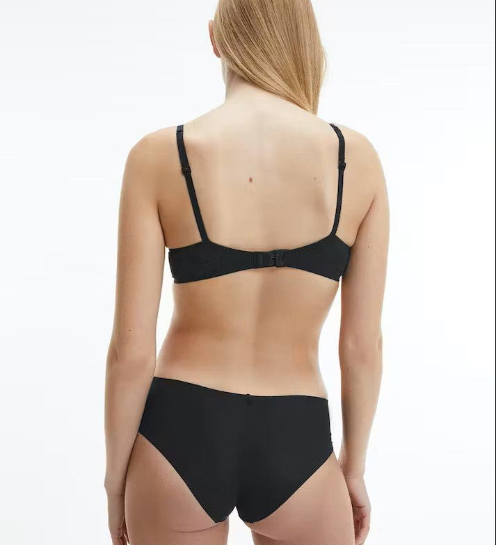 Back view of model in Calvin Klein Perfectly Fit T-Shirt Bra Black, showing adjustable straps and logo detail on the band.