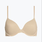 Calvin Klein Perfectly Fit T-Shirt Bra Bare laid flat, highlighting seamless nude microfibre material, moulded cups, and adjustable straps.