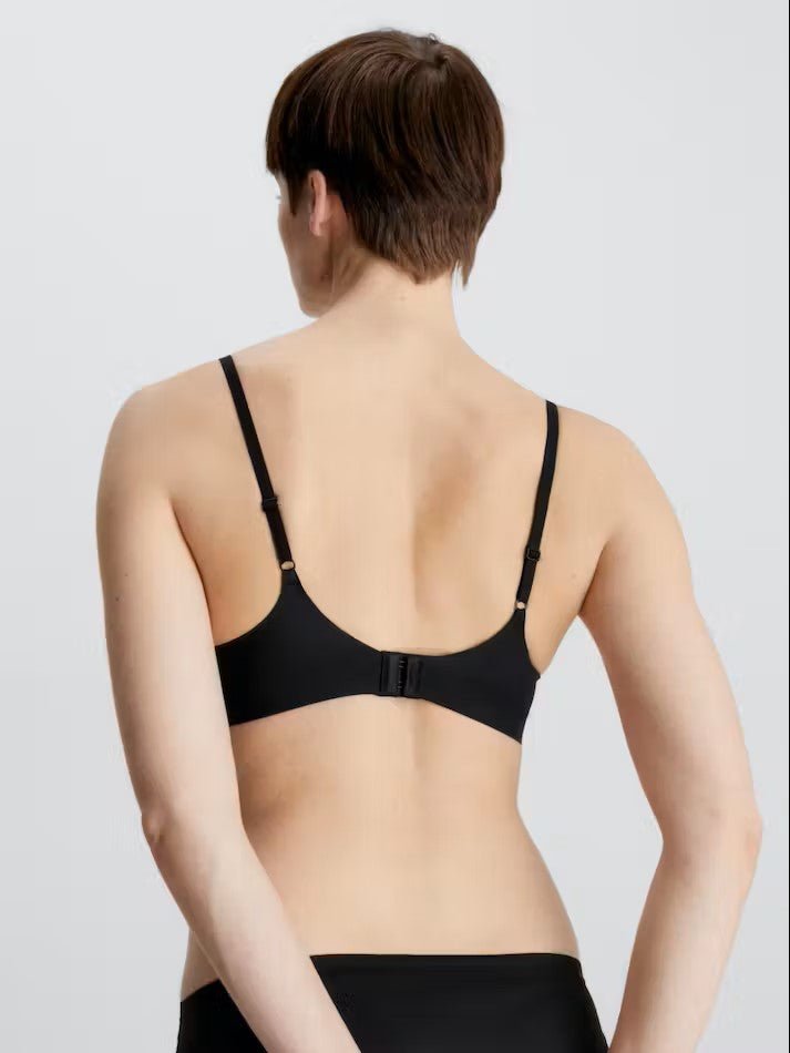 Back view of Liquid Touch Push Up Plunge Bra in Black by Calvin Klein—adjustable straps and hook closure shown, available at The Foundation.