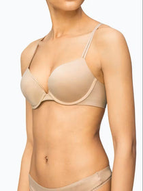 Calvin Klein Liquid Touch Push Up Plunge Bra in Bare, worn by model—available at The Foundation for a seamless lift with lace trim and microfibre fabric.