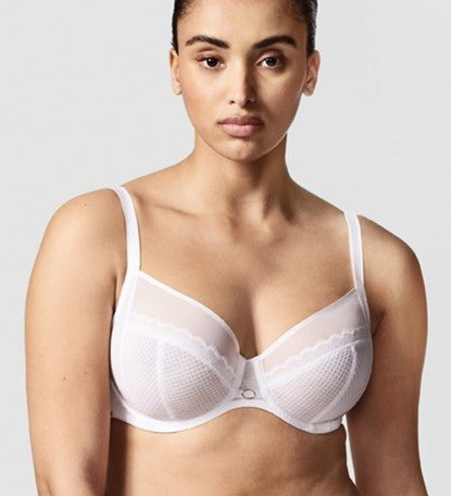 Model wearing Chantelle Parisian Allure Covering Bra in White from The Foundation, featuring semi-sheer cups, plunge neckline, and racerback straps.