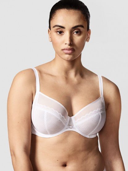 Model wearing Chantelle Parisian Allure Covering Bra in White from The Foundation, featuring semi-sheer cups, plunge neckline, and racerback straps.