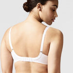 Model wearing Chantelle Parisian Allure Covering Bra in White from The Foundation, featuring semi-sheer cups, plunge neckline, and racerback straps. back view