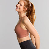 Woman wearing a sports bra and leggings on a gray background