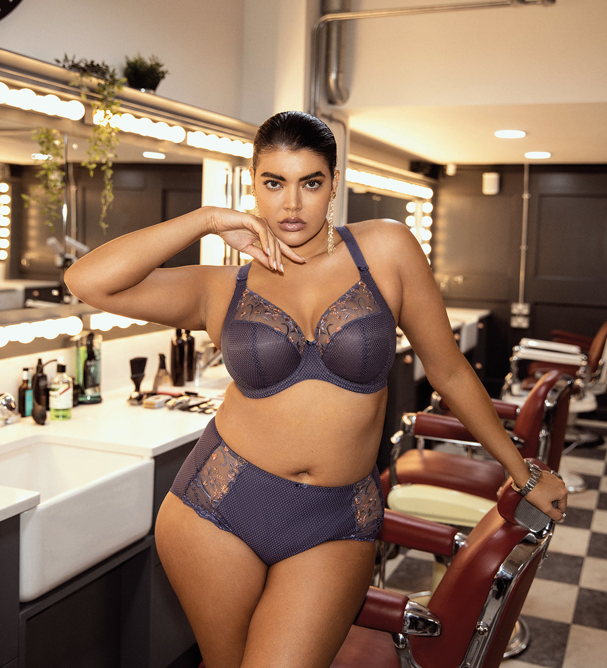 Model wearing Elomi Charley Plunge Bra in Storm, paired with matching briefs in a lifestyle setting.