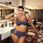 Model wearing Elomi Charley Plunge Bra in Storm, paired with matching briefs in a lifestyle setting.