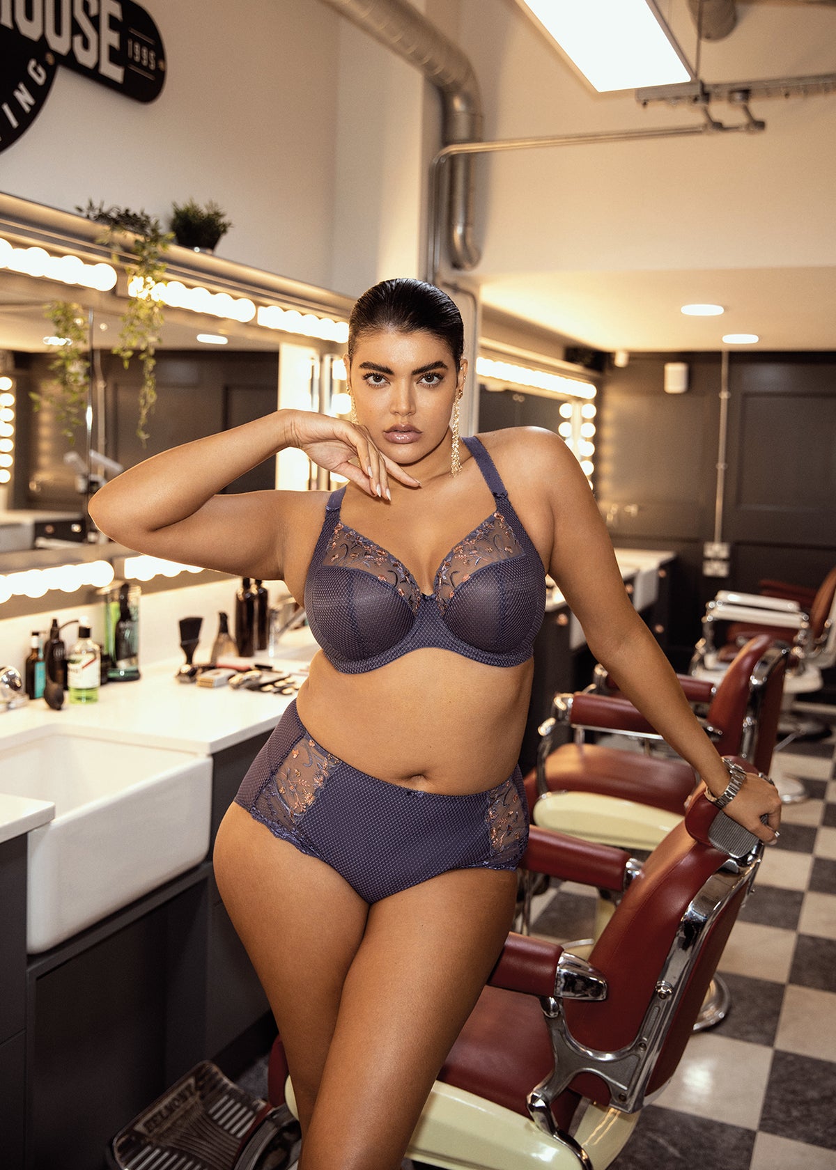 Model wearing Elomi Charley Plunge Bra in Storm, paired with matching briefs in a lifestyle setting.