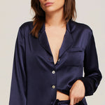 Close up of Model in Ginia Fine Finishes Silk Pyjama Midnight showing collared V neckline and silky texture.