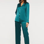 Model wearing Ginia Fine Finishes Silk Pyjama in Emerald with collared V-neck and full-length pants.