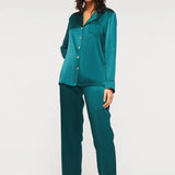 Model wearing Ginia Fine Finishes Silk Pyjama in Emerald with collared V-neck and full-length pants.