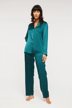 Model wearing Ginia Fine Finishes Silk Pyjama in Emerald with collared V-neck and full-length pants.