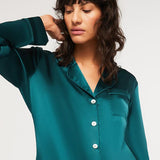 Close-up of Ginia Silk Pyjama Emerald top with pearl buttons and silk piping detail.