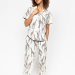 Front view of the Cyberjammies Georgina Giraffe Print Pyjama Set, showcasing the pointed collar top and wide-leg pants with drawstring and pockets