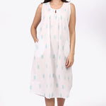 Woman wearing a sleeveless dress with a pattern on a white background