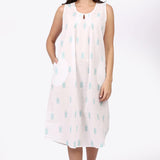 Woman wearing a sleeveless dress with a pattern on a white background