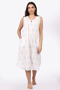 Woman wearing a sleeveless dress with a pattern on a white background