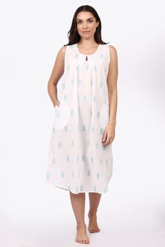 Woman wearing a sleeveless dress with a pattern on a white background