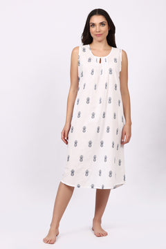 Woman wearing a white sleeveless cotton nightdress with navy patterns on a white background