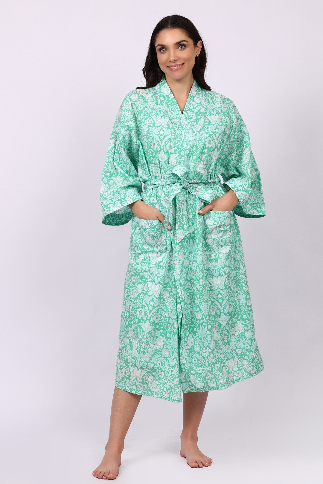 Woman wearing a green floral cotton robe on a white background