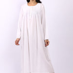 Woman wearing Lotus Sara long sleeve white cotton nightdress with pintuck bodice and rounded neckline.