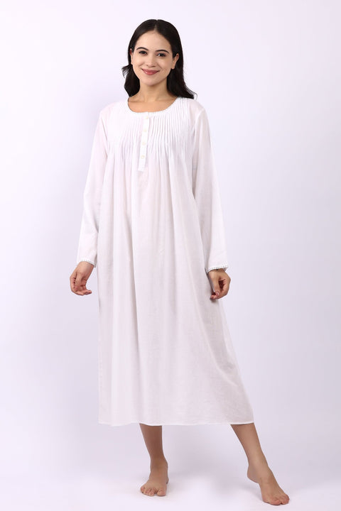 Woman wearing Lotus Sara long sleeve white cotton nightdress with pintuck bodice and rounded neckline.