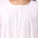 Close-up of pintuck detailing and buttoned neckline on Lotus Sara long sleeve cotton nightdress.