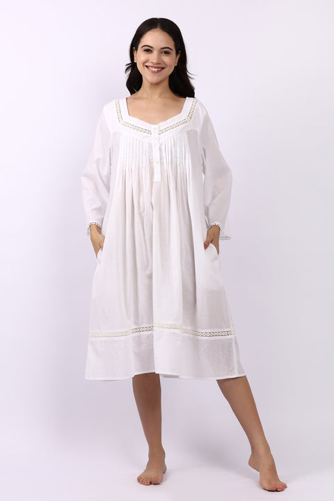 Woman wearing Lotus Susie white cotton nightdress with 3/4 sleeves, lace trim and pintuck bodice.