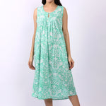 Woman wearing sleeveless cotton nightdress in spearmint green with Strawberry Thief print, keyhole neckline, and relaxed fit.